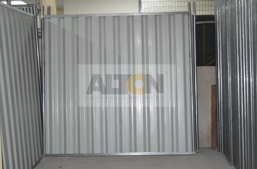 Large metal sliding gate with partially open, at an industrial site.