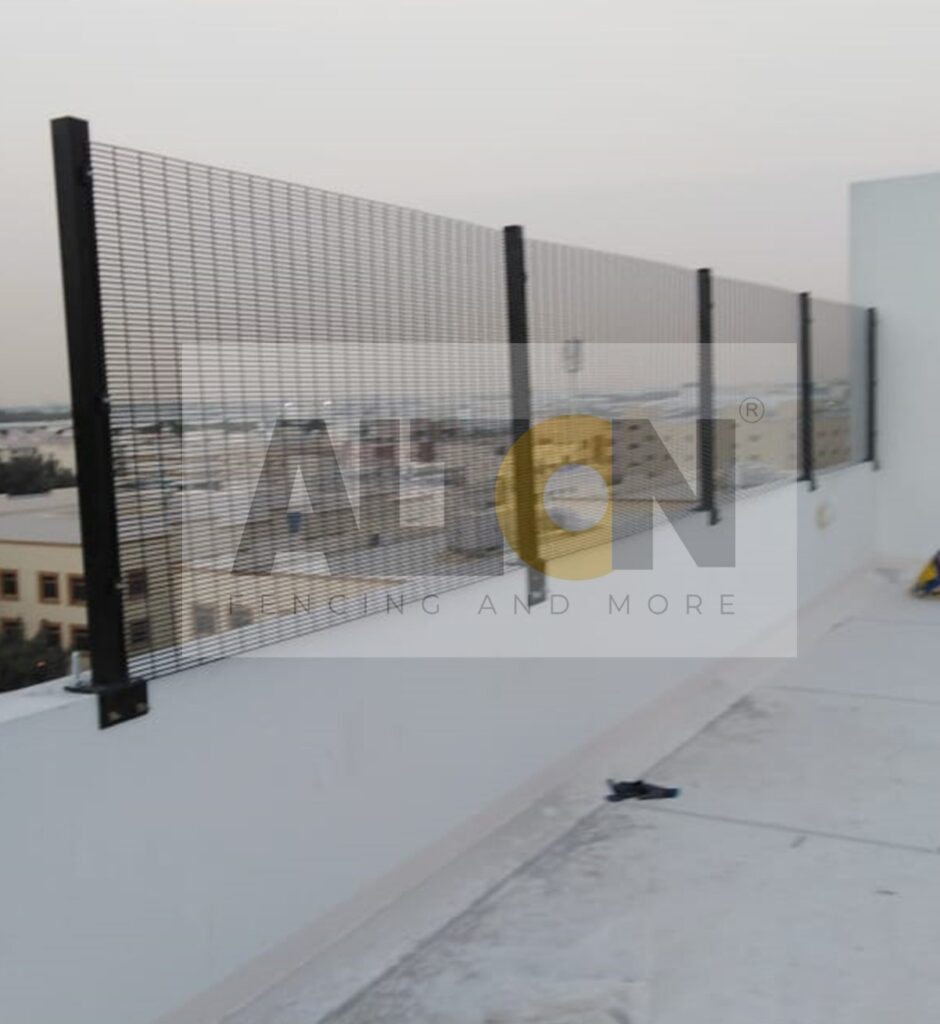 Pair of closed metal gates with a mesh pattern, leading to an industrial or commercial area.