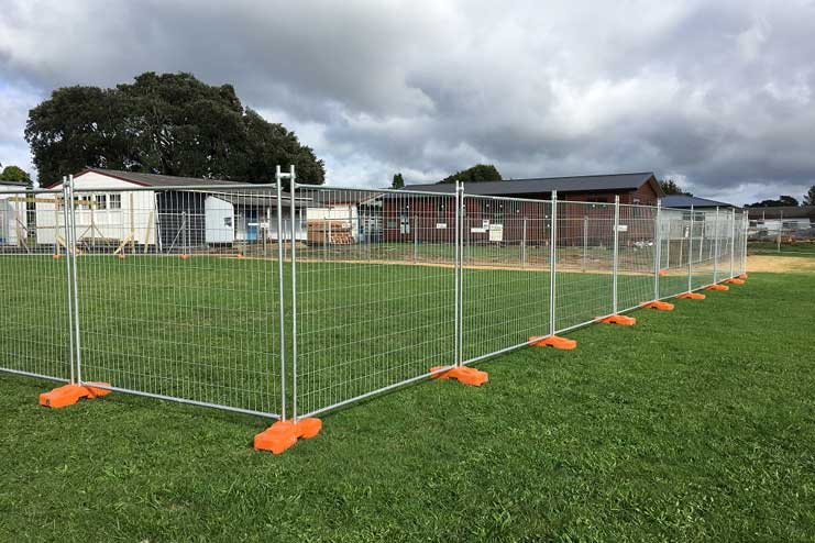 a fenced green field with orange legs